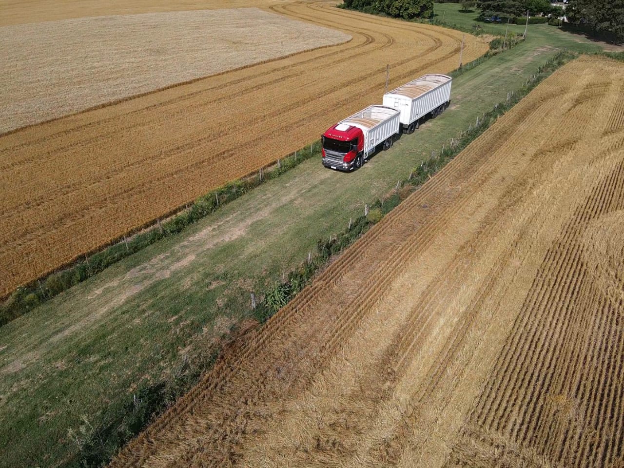 Camión con dos tolvas de grano entre lotes cosechados