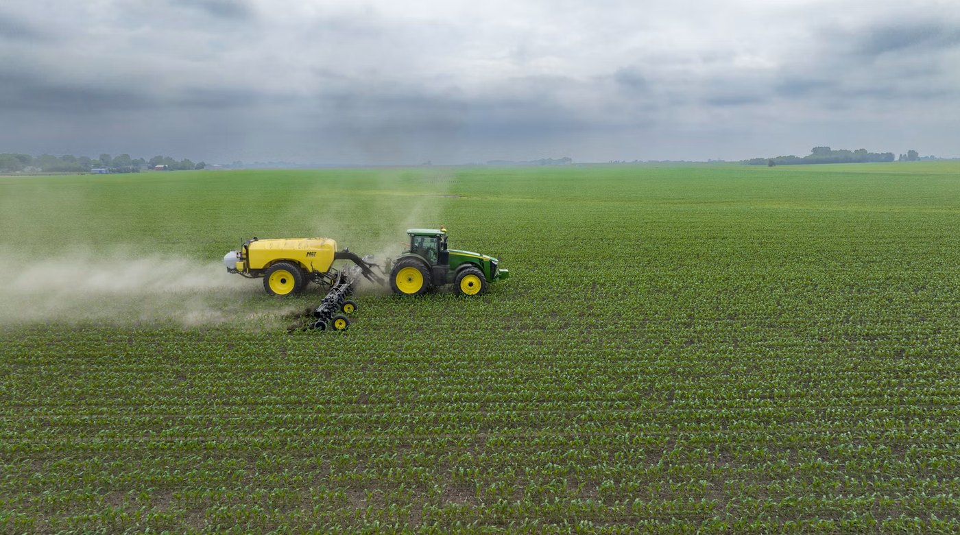 Pulverizadora cruzando un lote de cultivo