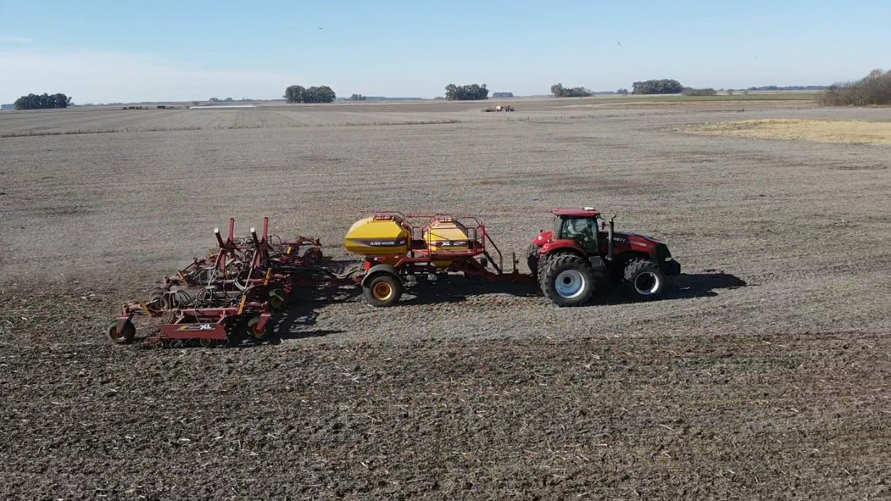 Tractor y sembradora trabajando un lote visto desde el aire